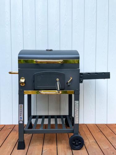 a black grill sitting on top of a wooden floor at Zloty, a Skromny - ogrodzony domek z jacuzzi i widokiem na jezioro in Górzno