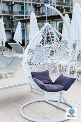 a white swing chair sitting on a patio at Hotel Carmen Azzuro in Venus