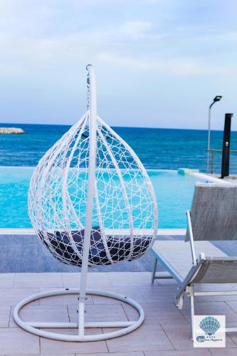 a net sitting next to a bench next to the ocean at Hotel Carmen Azzuro in Venus