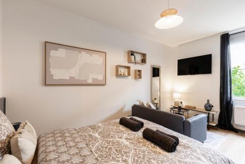 a bedroom with a bed and a tv on the wall at Le VD - appartement T2 proche gare et centre-ville in Bourg-en-Bresse