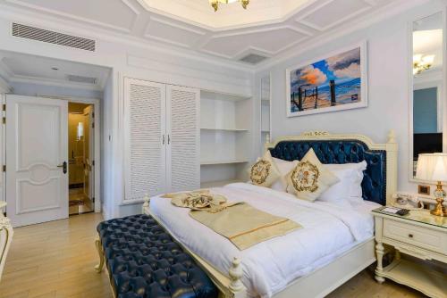 a bedroom with a blue and white bed and a desk at Lan Rung Beach Resort in Long Hai