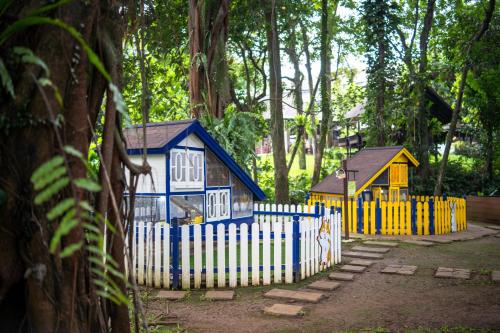 a small blue and yellow house behind a fence at Novotel Bogor Golf Resort in Bogor