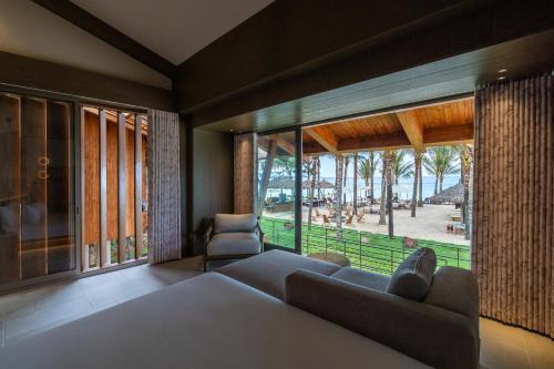 a living room with a couch and a large window at Harvest Day Hoi An in Hoi An