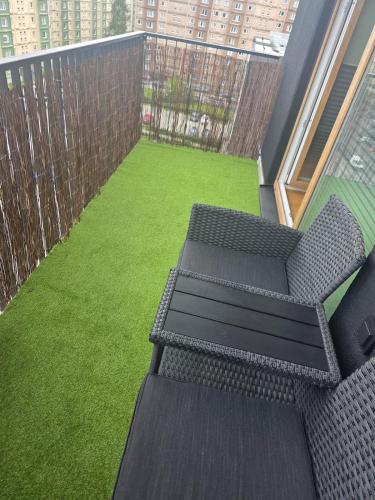 a balcony with two chairs and a green lawn at Spacious and cozy apartment in Tartu in Tartu