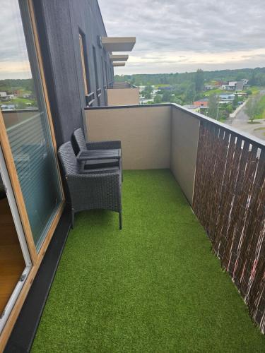a balcony with two chairs and green grass at Spacious and cozy apartment in Tartu in Tartu