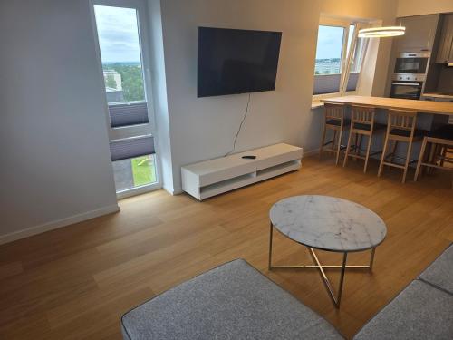 a living room with a table and a tv at Spacious and cozy apartment in Tartu in Tartu