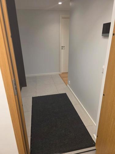 a hallway with a door and a black rug at Spacious and cozy apartment in Tartu in Tartu