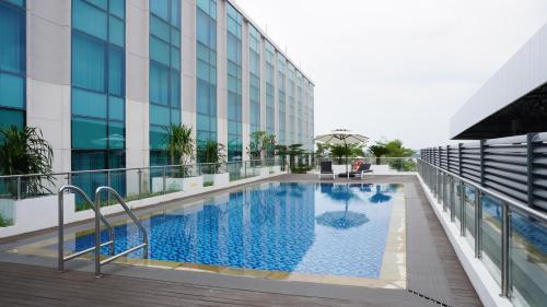 a swimming pool on the side of a building at Grand Anara Airport Hotel in Tangerang