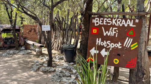 a sign that is next to some trees at Roy's Rest Camp in Groutfontein