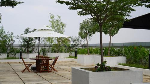 a patio with a table and an umbrella at Grand Anara Airport Hotel in Tangerang