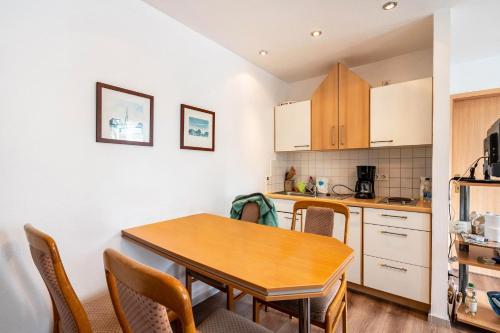 a small kitchen with a wooden table and chairs at Bungalow 179 in Stelzendorf