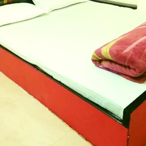 a red and white bed with a red and black frame at Hotel Pine City in Shillong