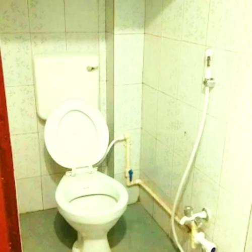 a bathroom with a white toilet in a stall at Hotel Pine City in Shillong