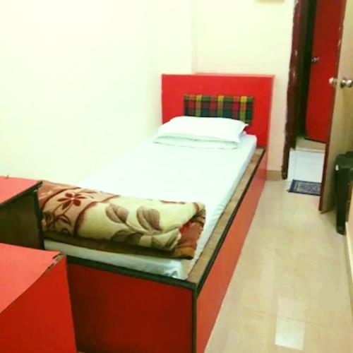 a small bed in a room with a red frame at Hotel Pine City in Shillong