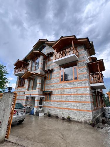 a building with a balcony on the side of it at The Highgrove House, Manali in Haripūr