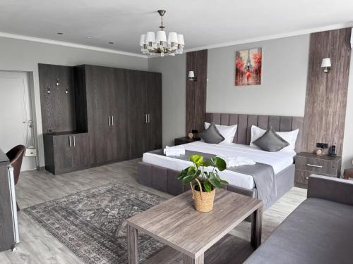 比什凯克Kausar Hotel的一间卧室配有一张床、一张桌子和一张沙发