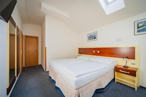 a bedroom with a large white bed in a room at Hotel Atos in Prague