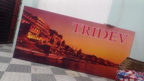 a sign on a wall that reads trilogy at Tridev paying guest house in Varanasi