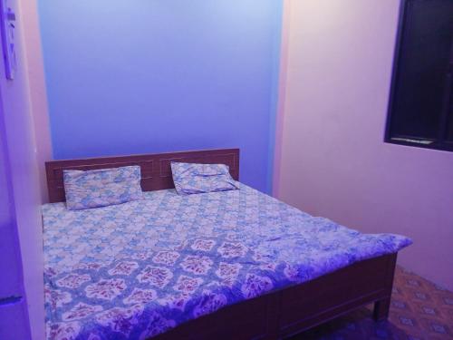 a bedroom with a bed with purple sheets and a tv at Tridev paying guest house in Varanasi
