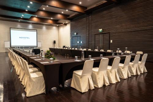 a large meeting room with a long table and chairs at Novotel Bogor Golf Resort in Bogor