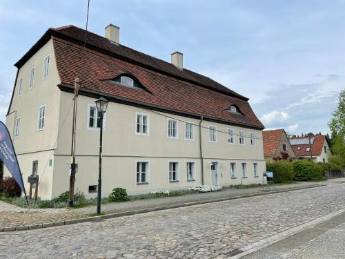 a large white building with a brown roof on a street at Gärtnereihaus in Fürstlich Drehna - Spreewald in Luckau