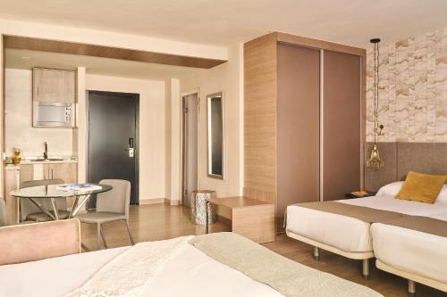 a bedroom with a bed and a table and a dining room at Ona Marbella Inn in Marbella