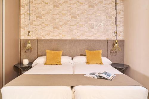 two beds in a room with two books at Ona Marbella Inn in Marbella