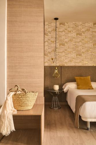 a bedroom with a bed and a basket on a table at Ona Marbella Inn in Marbella