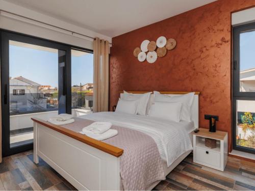 Un dormitorio con una cama blanca y una ventana grande. en Villa Riva Vir I, en Vir