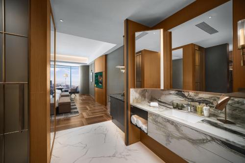 a bathroom with a sink and a mirror at MaxX by Steigenberger Harbour-view Qingdao in Qingdao