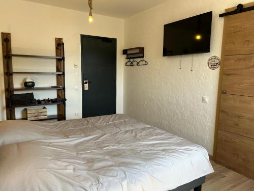a bedroom with a bed and a flat screen tv at Gite Clé des Champs in Montenois