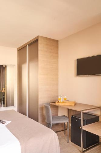 a hotel room with a desk and a tv at Ona Marbella Inn in Marbella