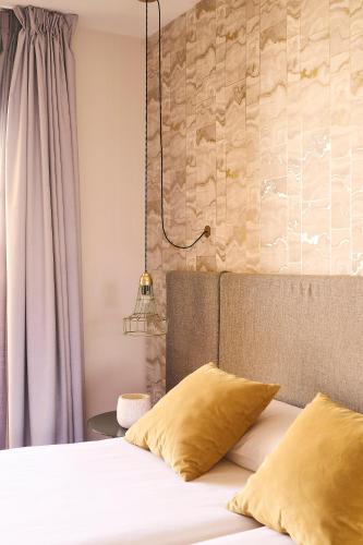 a bedroom with a bed with yellow pillows on it at Ona Marbella Inn in Marbella