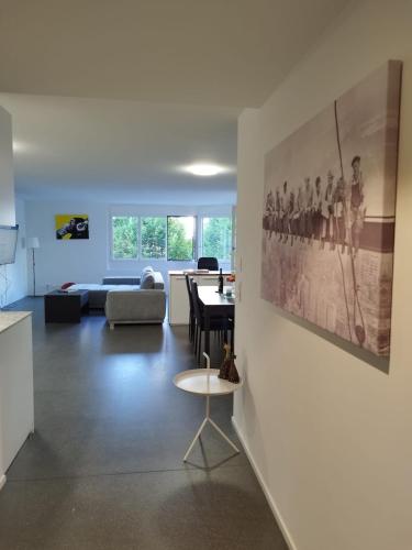 a living room with a table and a painting on the wall at PRIVATE APARTMENT - High End - Very spacious and quiet in Lausanne