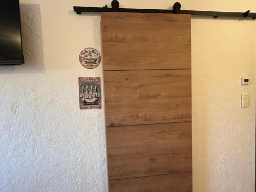 a wooden door with some stickers on a wall at Gite Clé des Champs in Montenois