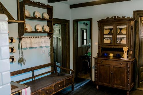 a room with a wooden cabinet and a wooden bench at Starodawna Chata - Dziad in Zamość