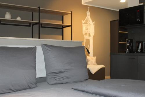 a bed with gray pillows and a chair in a room at Exklusives Wohnen im historischen Wasserturm dem Highlight von Delitzsch WE318 in Delitzsch