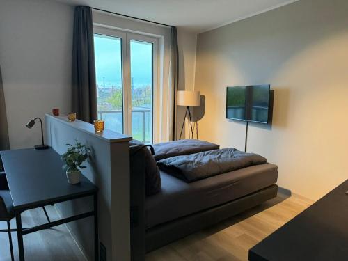 a living room with a couch and a large window at Exklusives Wohnen im historischen Wasserturm dem Highlight von Delitzsch WE318 in Delitzsch