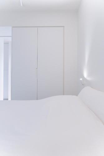a room with white walls and a mirror at La Brise Marine in Ostend