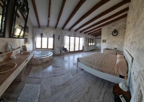 Un dormitorio con una cama, una bañera y un lavabo. en Gold Valentia El Nido, en Fanadix