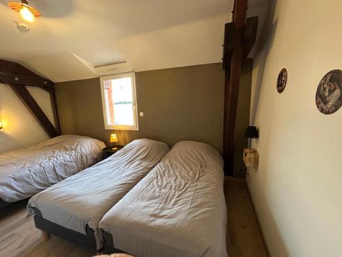 a small bedroom with two beds and a window at Gite Clé des Champs in Montenois