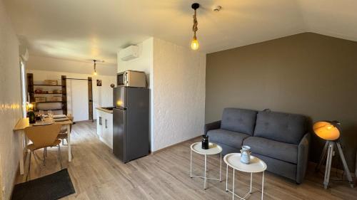 a living room with a couch and a kitchen at Gite Clé des Champs in Montenois