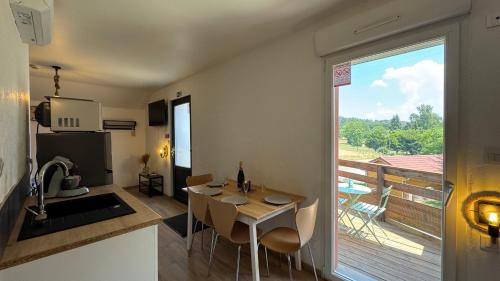 a kitchen and dining room with a table and a balcony at Gite Clé des Champs in Montenois