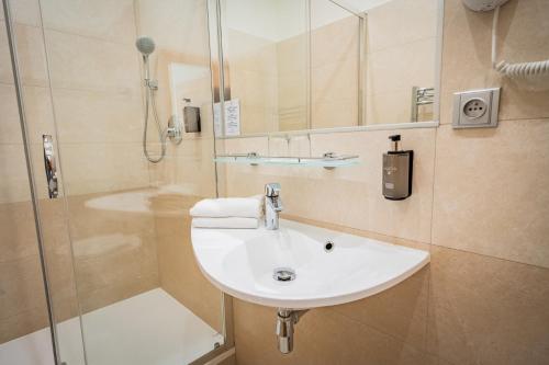 a bathroom with a sink and a shower at Hotel Atos in Prague