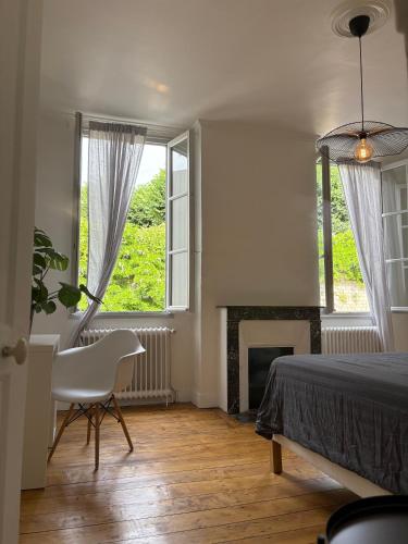 - une chambre avec un lit, une chaise et une cheminée dans l'établissement Jolie maison centre ville de Niort, à Niort