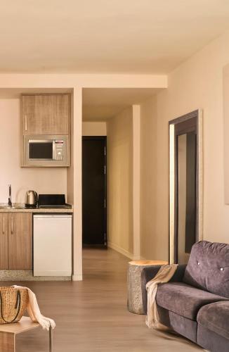 a living room with a couch and a kitchen at Ona Marbella Inn in Marbella