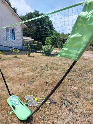 a green racket and two tennis rackets in a yard at Les Bruyères de Jeanne et René Zoo de Beauval à 20min,Châteaux TOUT INCLUS in Fontguenand