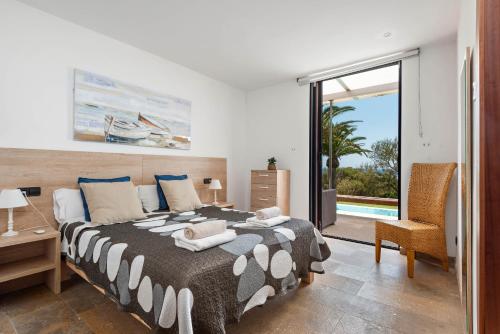 a bedroom with a bed and a sliding glass door at Villa Rosa in Punta Prima