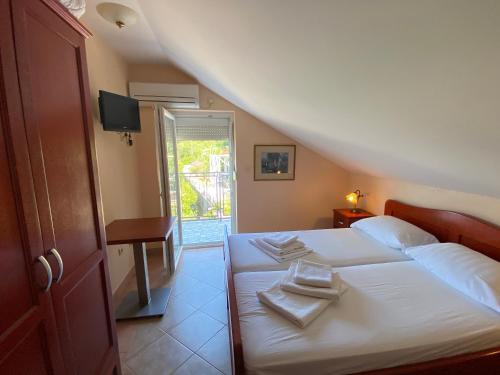 a bedroom with a bed with towels on it at Vila Ćorović in Kumbor