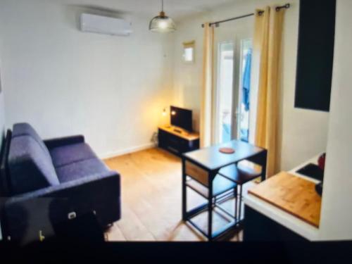 un salon avec un canapé et une table dans l'établissement Studio climatisé aux plages 1, à Sète